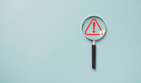 Magnifier glass with red triangle caution warning sign for notification error and maintenance...