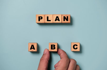 Hand holding B wording on wooden cube block for backup plan selection of business planing concept.の写真素材
