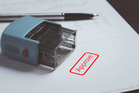 Closeup of stamper with red approve wording on paper for approve document , business project permit and ISO certificate concept.の写真素材