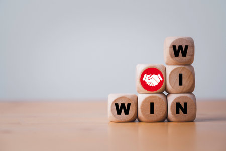 Win and win wording with hand shaking icon on wooden cube block for success and business deal situation concept.の写真素材