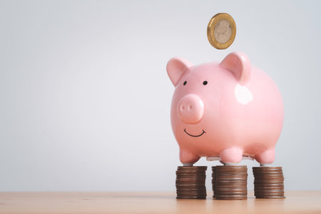 Pink piggy bank standing on coins stacking with copy space for deposit banking of investment , retirement to get profit and interest concept.の写真素材