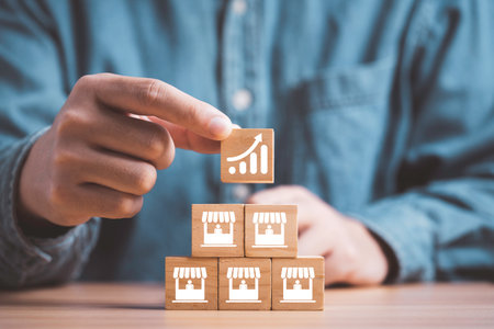 Businessman stacking increasing graph on store illustration print screen on wooden cube block for business sale growth and expand shop franchise concept.の写真素材