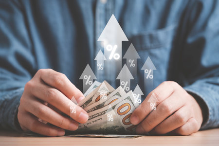 Businessman holding and counting USD dollar banknote with up arrow and percentage sign for interest rating growth to tackle with inflation increasing concept.の写真素材