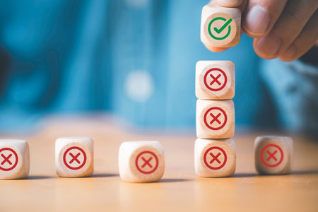 Businessman stacking green correct sign mark on top of Red Cross mark which print screen on wooden...