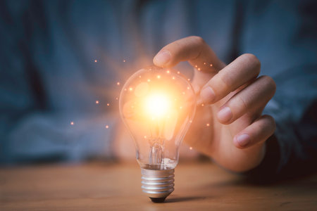 Businessman hand touching glowing lightbulb to creative smart thinking idea for inspiration and innovation concept.の写真素材