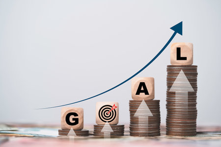 Goal wording with dartboard with arrow on increasing coins stacking for financial economy and investment target concept.の写真素材