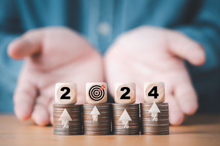 Businessman hand give wooden block cube 2024 with dartboard on coins stacking for setup objective target business cost and budget planing of new year concept.の写真素材