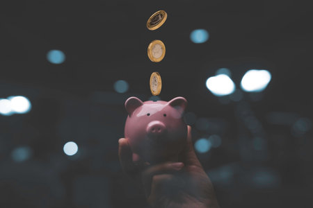 Businessman holding pink piggy bank with dropping coins  , Money saving and deposit for investment to get profit and dividend concept.の写真素材