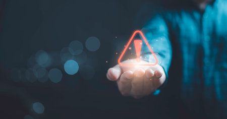Red triangle caution warning sign on hand for maintenance notification error and risk concept.の写真素材