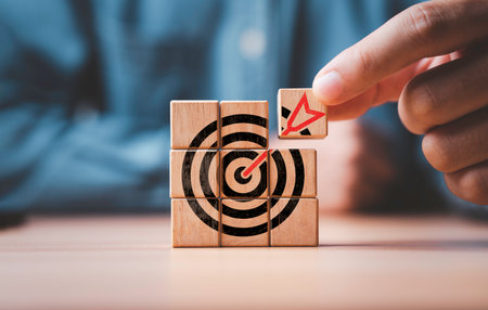 Businessman assembly target board with arrow which printing on wooden cube block for set up business objective target  and goal concept.の写真素材