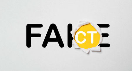 Fake and Fact inside of pushed paper for negative and positive mindset concept , April fools day.の写真素材