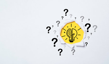 Lightbulb drawing inside of punch paper with questions mark for creative thinking idea and problem solving concept.の写真素材