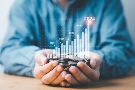 Businessman hand holding coins money with virtual increasing graph  , Business investment profit and deposit dividend saving growth concept.の写真素材