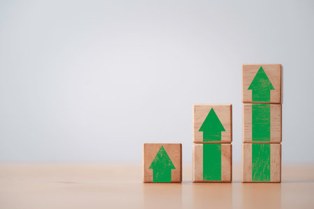 Green increasing up arrow print screen on wooden cube block ,It is symbol of business investment growth concept.の写真素材