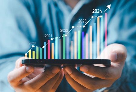 Businessman holding smartphone with virtual technical graph and chart for analysis stock market, technology investment and value investment concept.の写真素材