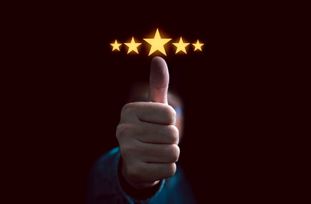 Businessman hand thumb up with glowing yellow five stars for client the best satisfaction evaluation survey after use product and service concept.の写真素材