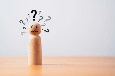 Wooden figure with many questions mark and copy space for doubt suspicion and doodle concept.の写真素材