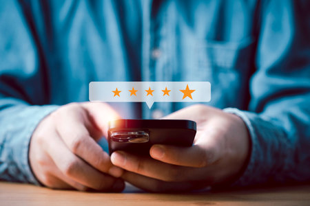 Businessman using smartphone to give golden five stars for client the best satisfaction evaluation survey after use product and service concept.の写真素材