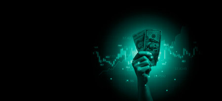 Hand holding USD dollar banknote with stock market chart and increasing arrow for dollar exchange , money exchange and inflation interest rating increasing concept.の写真素材