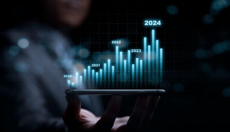 Businessman holding smartphone with technical stock market graph chart for trader analysis investment data to get increasing profit and high dividend , Financial banking and economic concept.の写真素材