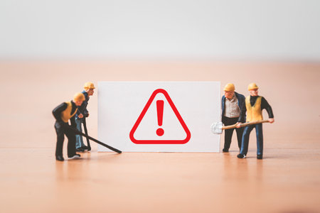 Worker and technician  miniature figure standing with caution exclamation sign to waring everybody work with safety first concept.の写真素材