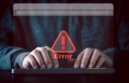 Businessman typing on computer keyboard with virtual monitor red triangle caution warning sign for notification error and maintenance concept.の写真素材