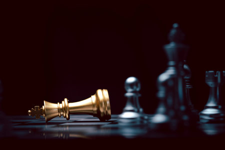 Fallen of golden king chess among  silver chess figure. Defeat and loss of business competition and marketing strategy planing concept.の写真素材