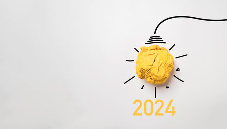 Yellow scrap paper ball for virtual lightbulb with 2024 on white background for creative thinking...