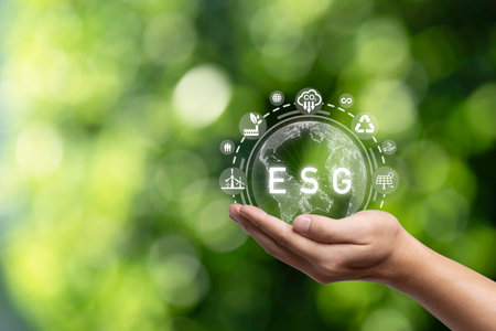 Hand holding virtual world with environmental icon on green background for Environment Social Governance to sustainable development in business and ecology concept.の写真素材