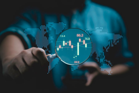 Businessman holding magnifier glass with stock market graph chart for focus and analysis stock...