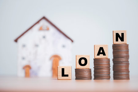 Loan wording on increasing coins stacking with house model background for financial from real estate mortgage growing after central bank increase interest rating concept.の写真素材