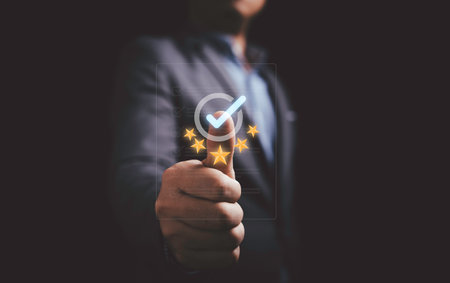 Businessman showing thumb up with correct sign mark and golden five stars on document for the best quality guarantee of product and service concept.の写真素材