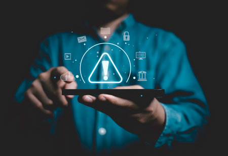 Businessman holding smartphone with red triangle caution warning sign for notification error and maintenance concept.の写真素材