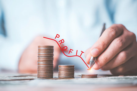 Businessman writing red down line with decreasing coins stacking for profit from business investment from economic depression crisis concept.の写真素材