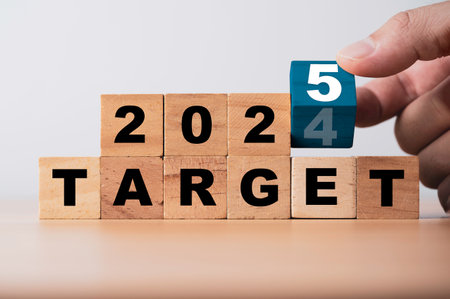 Hand flipping wooden block cube for change 2024 to 2025 on target wording for setup new business objective target and goal after change to new year concept.の写真素材