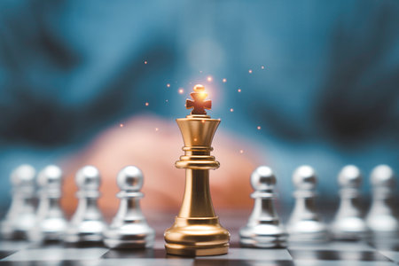 Golden king chess in front of silver pawn chess and businessman with glowing light for leadership and business assignment project concept.の写真素材