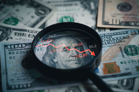 Red down arrow inside of magnifier glass and USD dollar banknote for United States of America or USA economic recession crisis and Fed reduce interest concept.の写真素材