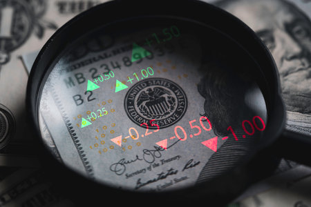 Closeup on magnifier glass with Benjamin Franklin on US dollar banknote and stock market graph for currency exchange and Interest rates concept.の写真素材