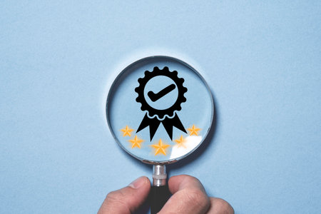 Businessman holding magnifier glass with the best quality assurance and golden five stars for focus guarantee product and ISO service concept.の写真素材