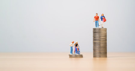Compare between miniature figure shopping persons standing on high coins stacking and parents with child on low coin stacking for no saving and high expense cost of parents.の写真素材