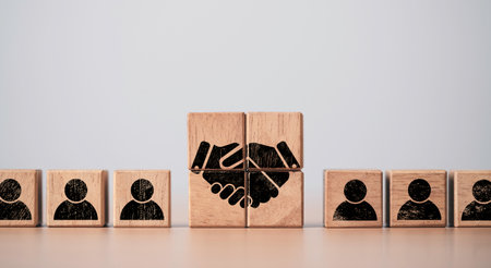 Hand shaking print screen on wooden block cube between human icon for business deal and agreement concept.の写真素材