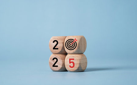 2025 with dartboard arrow print screen on wooden block cube for setup business setup objective  target and goal when change to new year concept.の写真素材