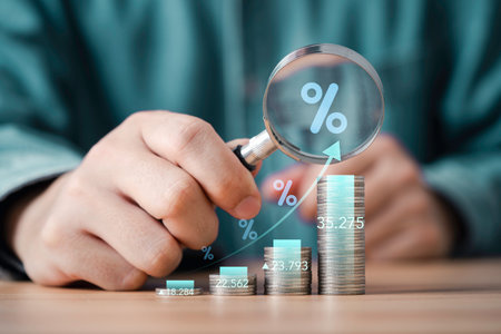 Businessman use magnifier glass focus to increasing coins money with percentage for analysis financial banking increase interest rate or mortgage investment dividend from business growth concept.の写真素材