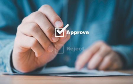 Businessman use pen to tick correct sign mark in checkbox with approve wording for quality document control checklist and business approval project concept.の写真素材