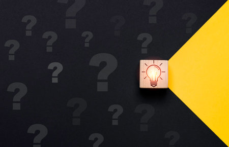 Glowing lightbulb on wooden block cube move yellow to black side with question mark for problem solving solution and curative thinking idea innovation concept.の写真素材