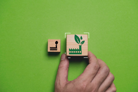 Hand holding to select between green factory and pollution manufacturing for green economy to reduce carbon dioxide emission from Kyoto protocol within 2050 ,Sustainability environment concept.の写真素材