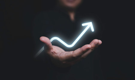 Glowing of up arrow on hand of businessman for business achievement growth of dividend profit...