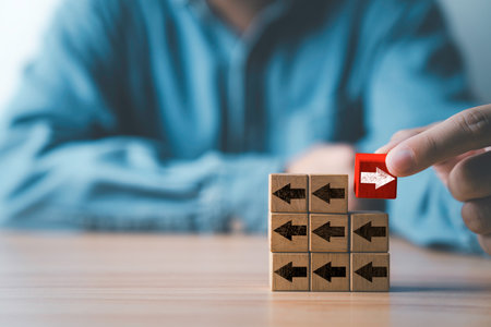Businessman holding white right arrow on red wooden block move in different direction with black...