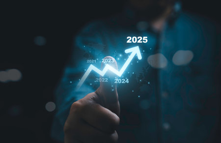 Businessman thumb up with glowing increasing arrow and 2025 year for business investment and trading growth in new year concept.の写真素材