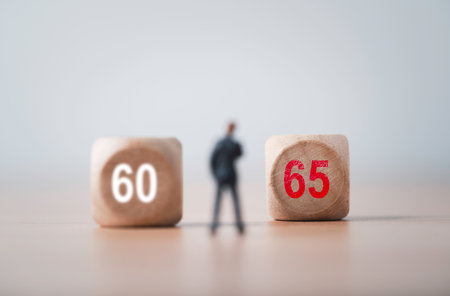 Defocus of businessman miniature figure with 60 and focus on 65 for extend of retirement period from 60 years old to 65 years old , Aging society concept.の写真素材